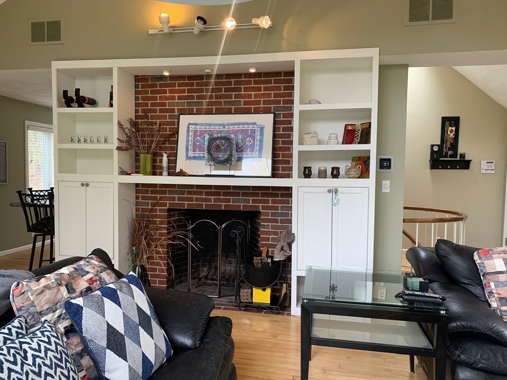 4 Potter Pond, Unit 4 Lexington, MA 02421 - Photo 4 of 15 a living room with furniture and a fireplace