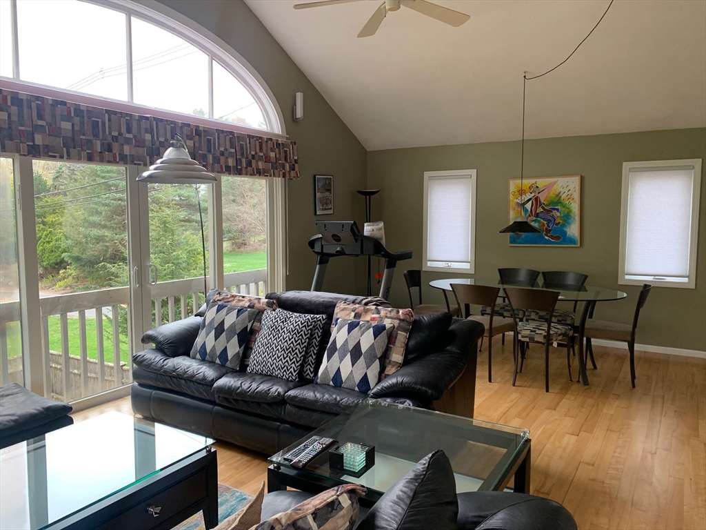 4 Potter Pond, Unit 4 Lexington, MA 02421 - Photo 6 of 15 a living room with furniture a wooden floor and a large window