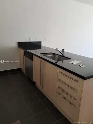 a kitchen with stainless steel appliances a sink a stove a microwave a counter top and a cabinets