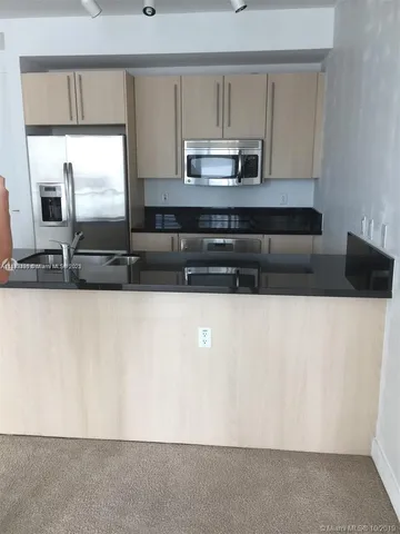 a kitchen with a sink and stainless steel appliances