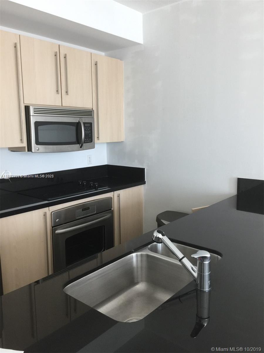 1111 Southwest 1st Avenue, Unit 1724N Miami, FL 33130 - Photo 14 of 17 a kitchen with a sink and stainless steel appliances
