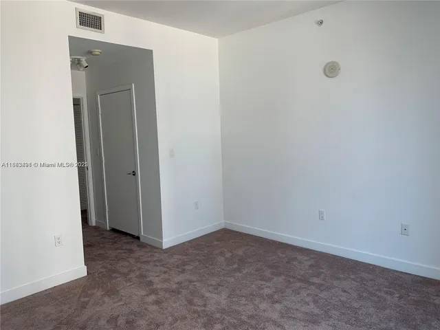 an empty room with closet and a window
