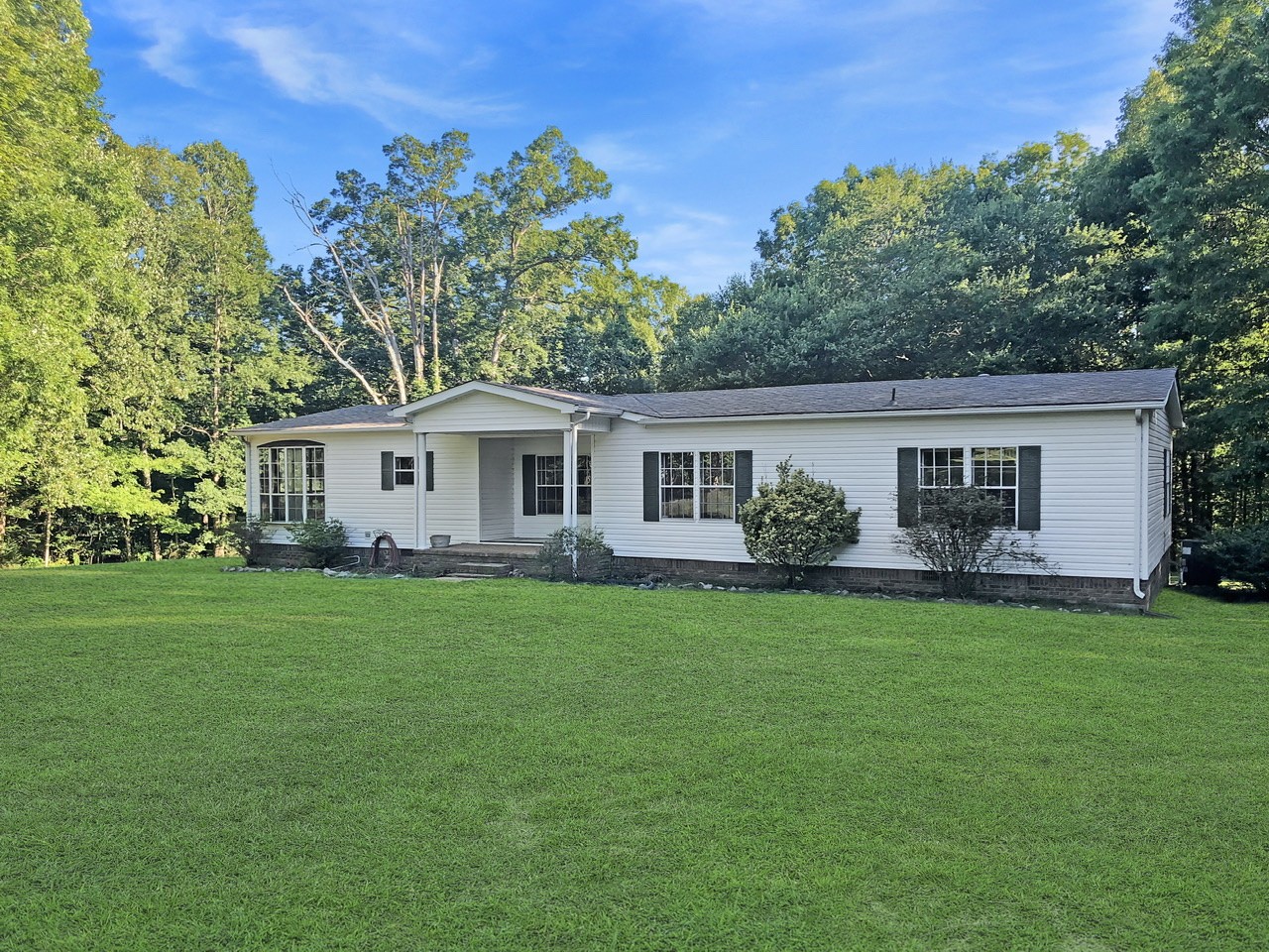 218 Watson Road Bumpus Mills, TN 37028 - Photo 2 of 23 a front view of a house with a garden
