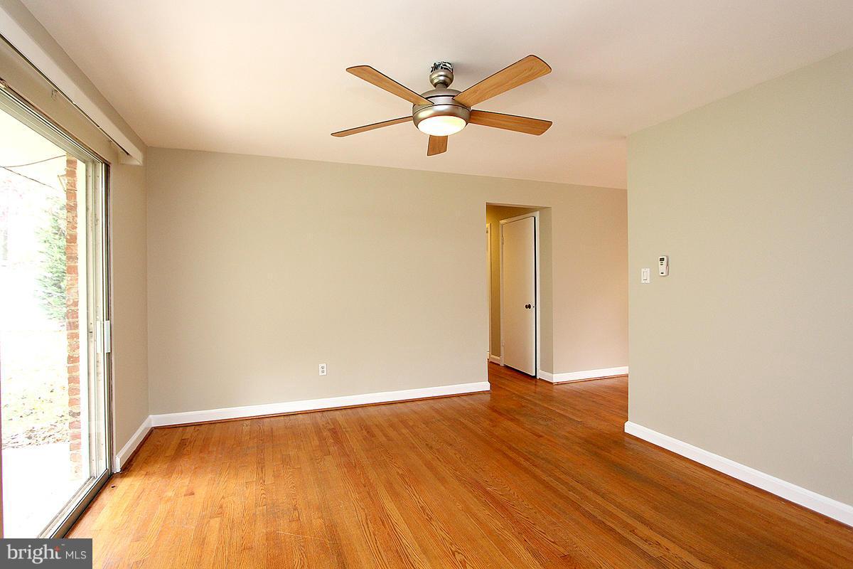17216 Donora Road Silver Spring, MD 20905 - Photo 14 of 28 an empty room with wooden floor fan and windows