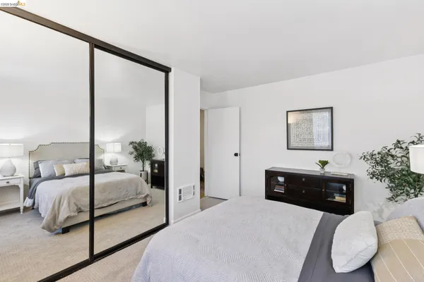 a bedroom with a large bed and a chandelier