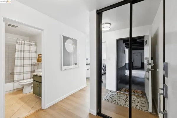 a view of a hallway with wooden floor and living room