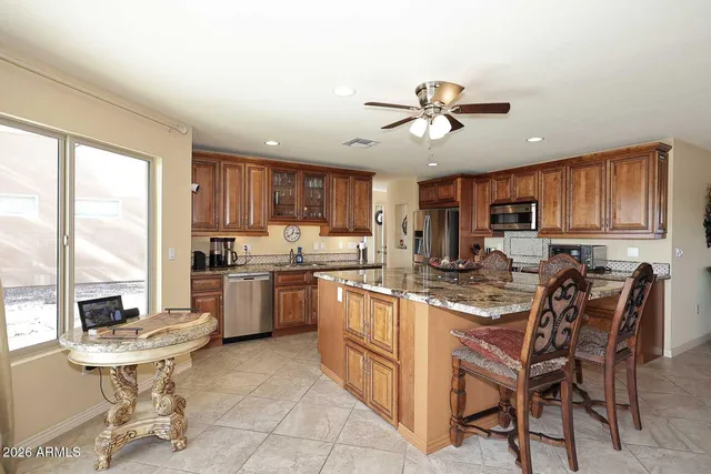 a kitchen with a dining table chairs stainless steel appliances and cabinets