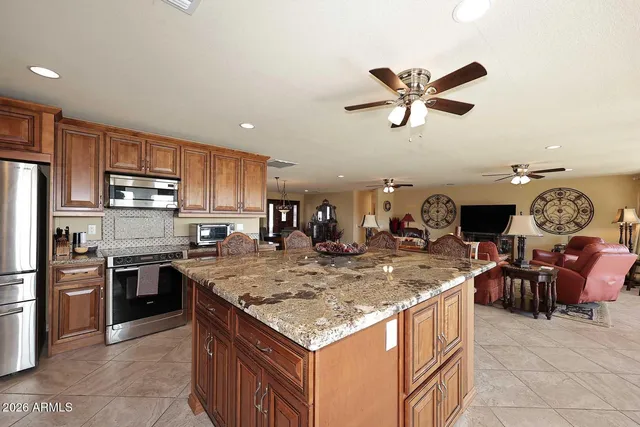 a kitchen with stainless steel appliances granite countertop table chairs sink and stove