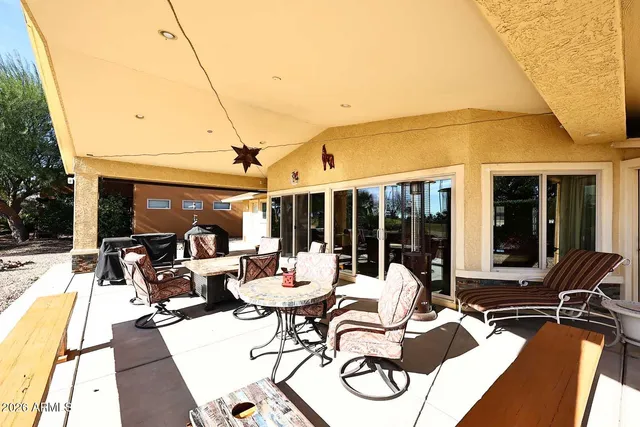 a living room with large windows and a table