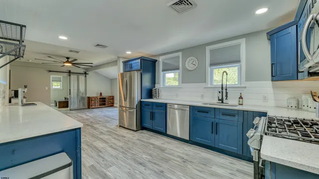 a large kitchen with kitchen island a sink stainless steel appliances and cabinets