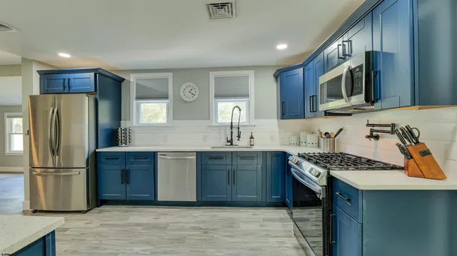 a kitchen with stainless steel appliances granite countertop a refrigerator stove and sink