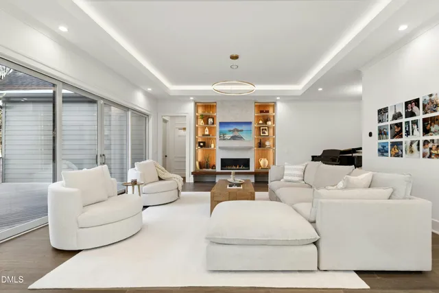 a living room with furniture kitchen view and large windows