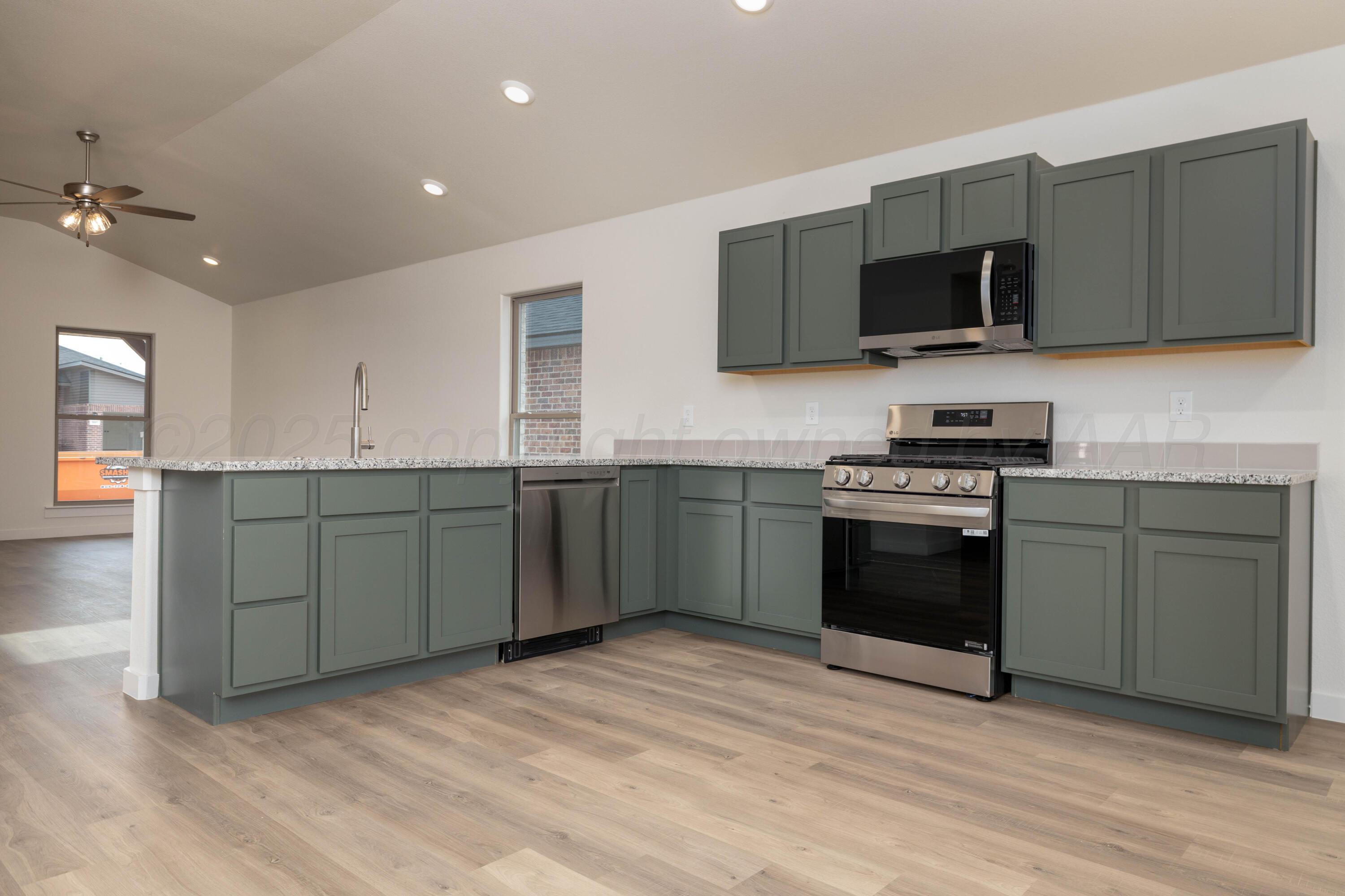 3106 Flycatcher Road Amarillo, TX 79124 - Photo 2 of 9 a kitchen with stainless steel appliances granite countertop a sink a stove top oven and microwave