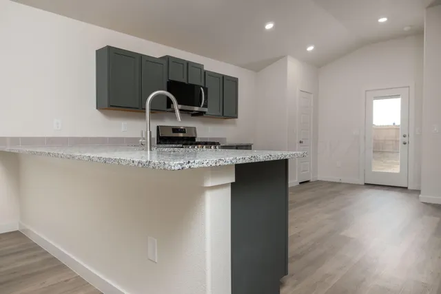 a kitchen with a sink and a stove top oven