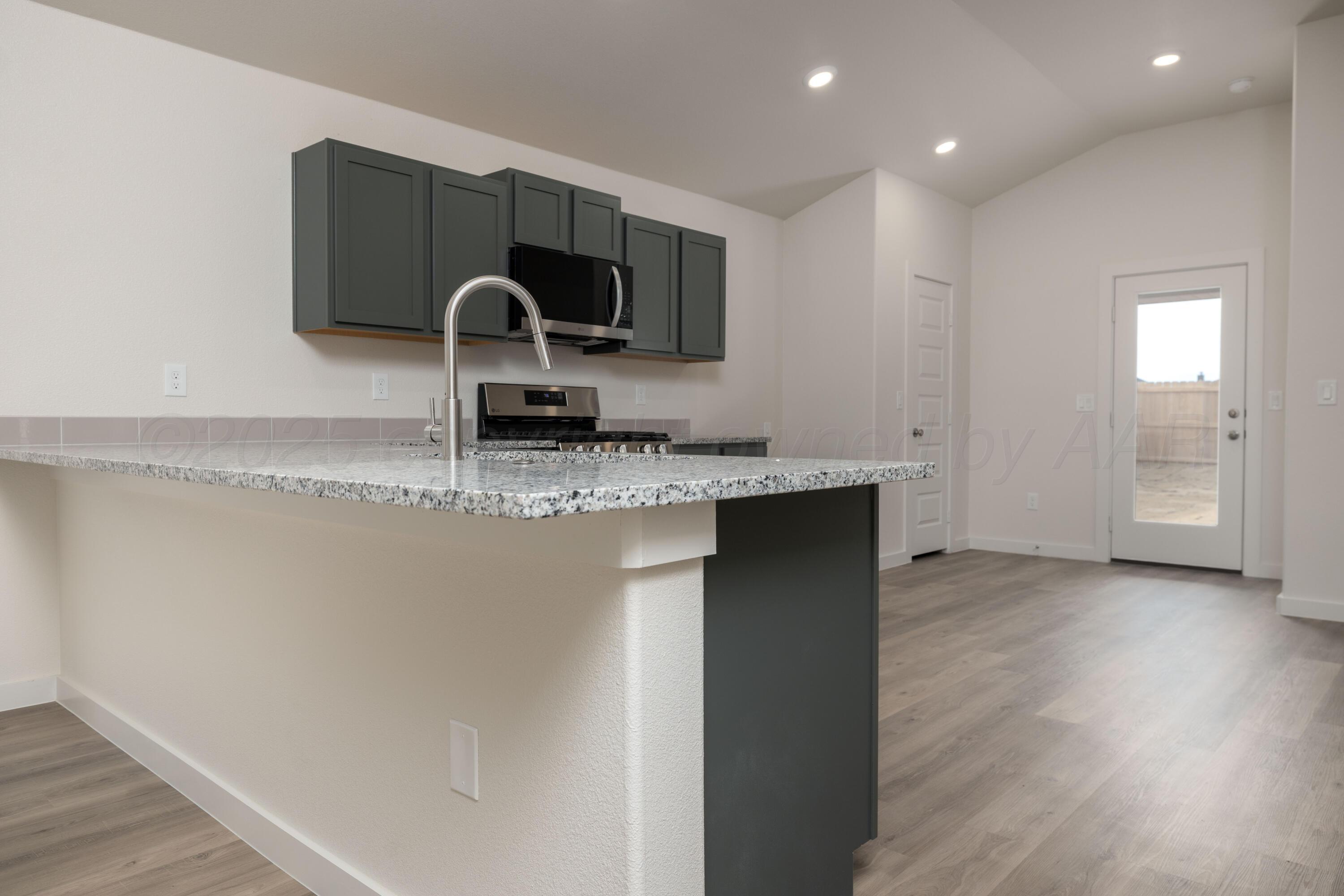 3106 Flycatcher Road Amarillo, TX 79124 - Photo 3 of 9 a kitchen with a sink and a stove top oven