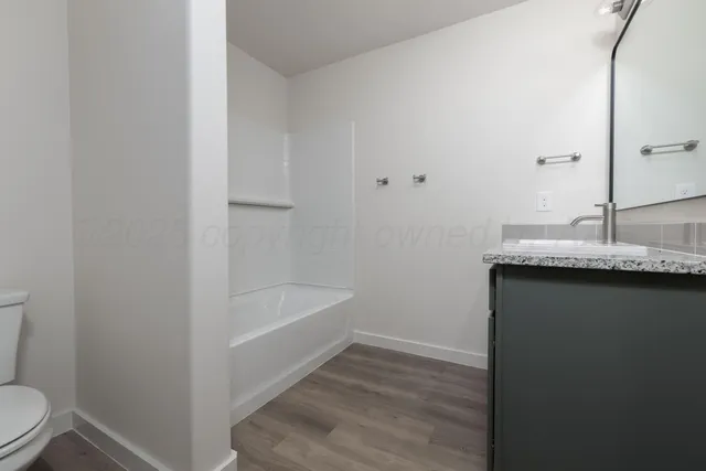 a bathroom with a granite countertop sink toilet and bathtub