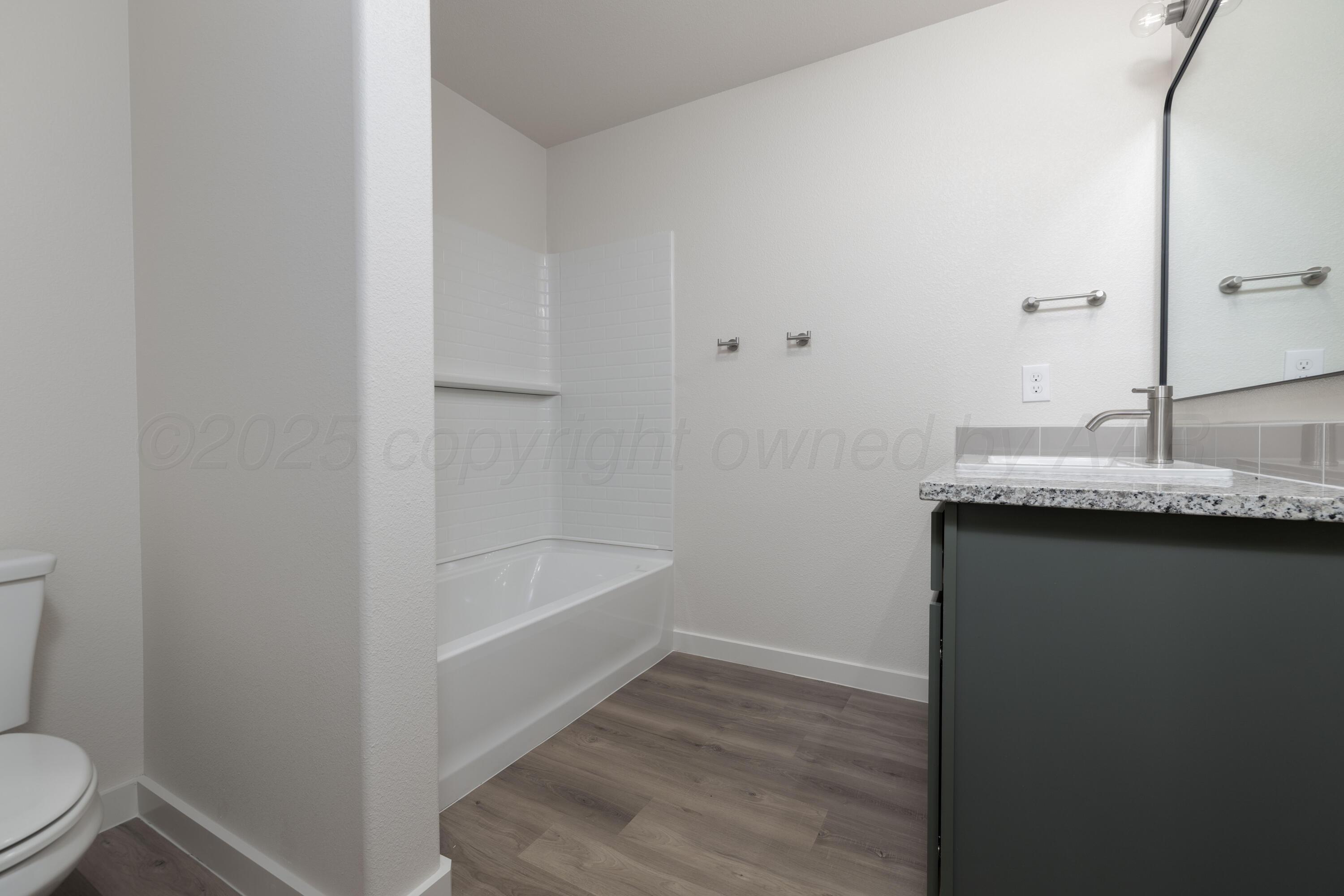 3106 Flycatcher Road Amarillo, TX 79124 - Photo 7 of 9 a bathroom with a granite countertop sink toilet and bathtub