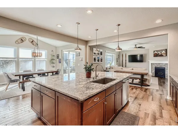 a kitchen with stainless steel appliances granite countertop a sink a stove and a wooden floors