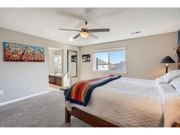 a bedroom with a bed and a painting on the wall