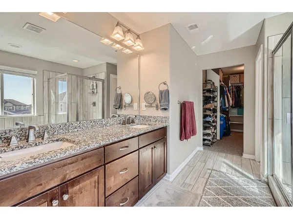 a spacious bathroom with a granite countertop double vanity sink and a mirror