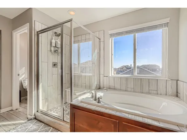 a bathroom with a granite countertop sink mirror and a bathtub