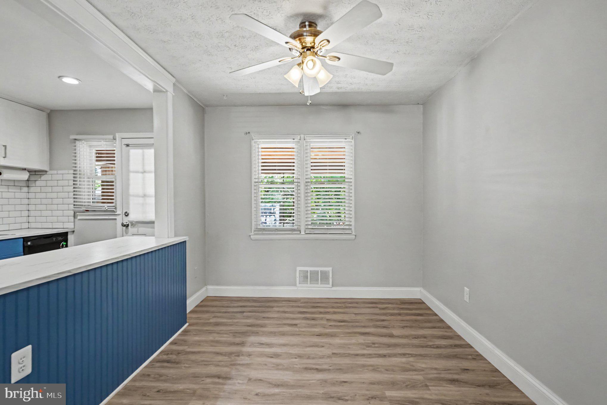 7729 Charlesmont Road Baltimore, MD 21222 - Photo 8 of 43 a view of an empty room with a window and wooden floor