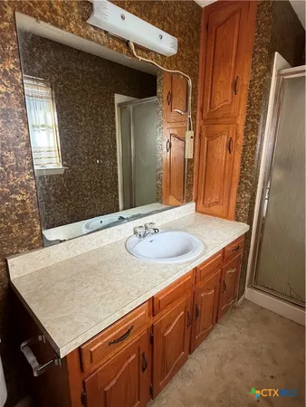 a bathroom with a granite countertop sink and a mirror
