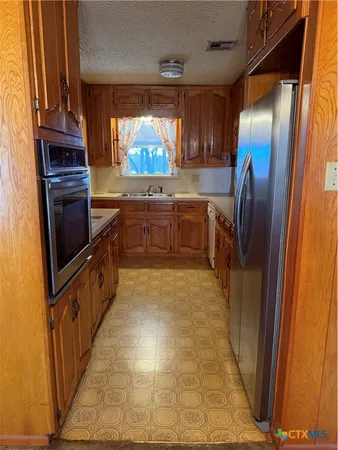 a kitchen with stainless steel appliances granite countertop a refrigerator and a stove