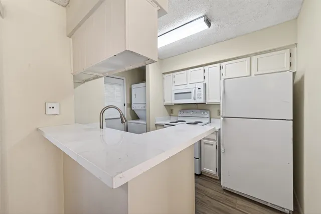 a kitchen with white cabinets and white appliances