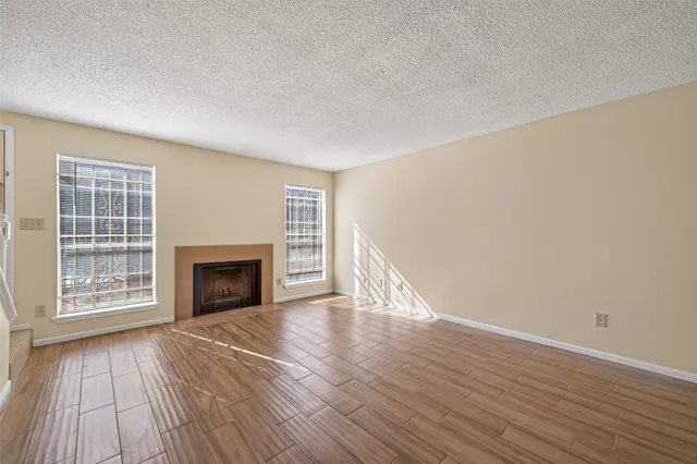 an empty room with wooden floor and fireplace