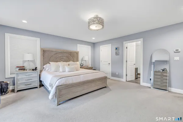 a spacious bedroom with a bed and a chandelier