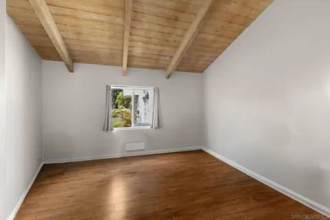 an empty room with windows and fireplace