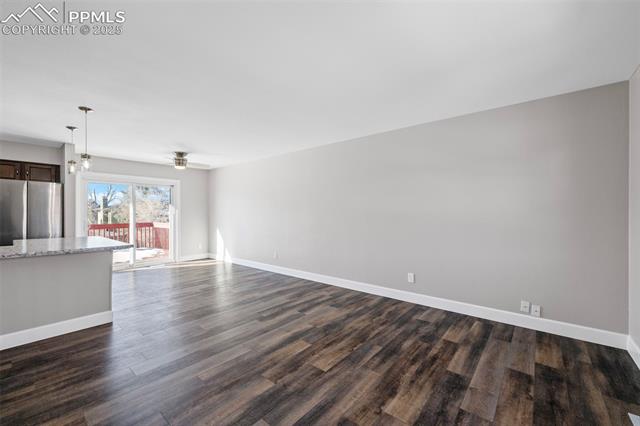 6319 Chippewa Road Colorado Springs, CO 80915 - Photo 14 of 36 Unfurnished living room with ceiling fan and dark hardwood / wood-style flooring