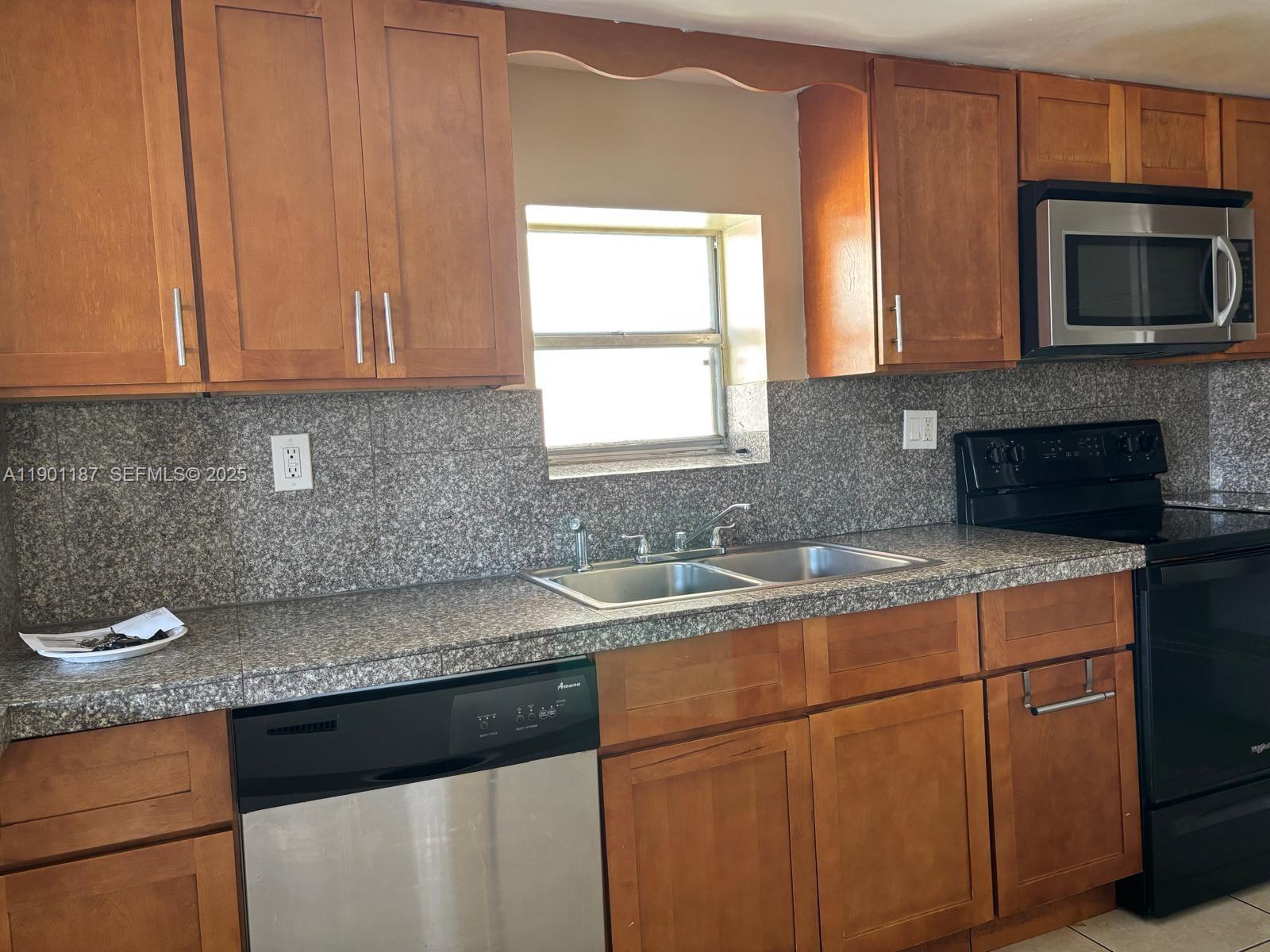 6541 Southwest 41st Court, Unit 173 Davie, FL 33314 - Photo 21 of 24 a kitchen with granite countertop a sink and a stove