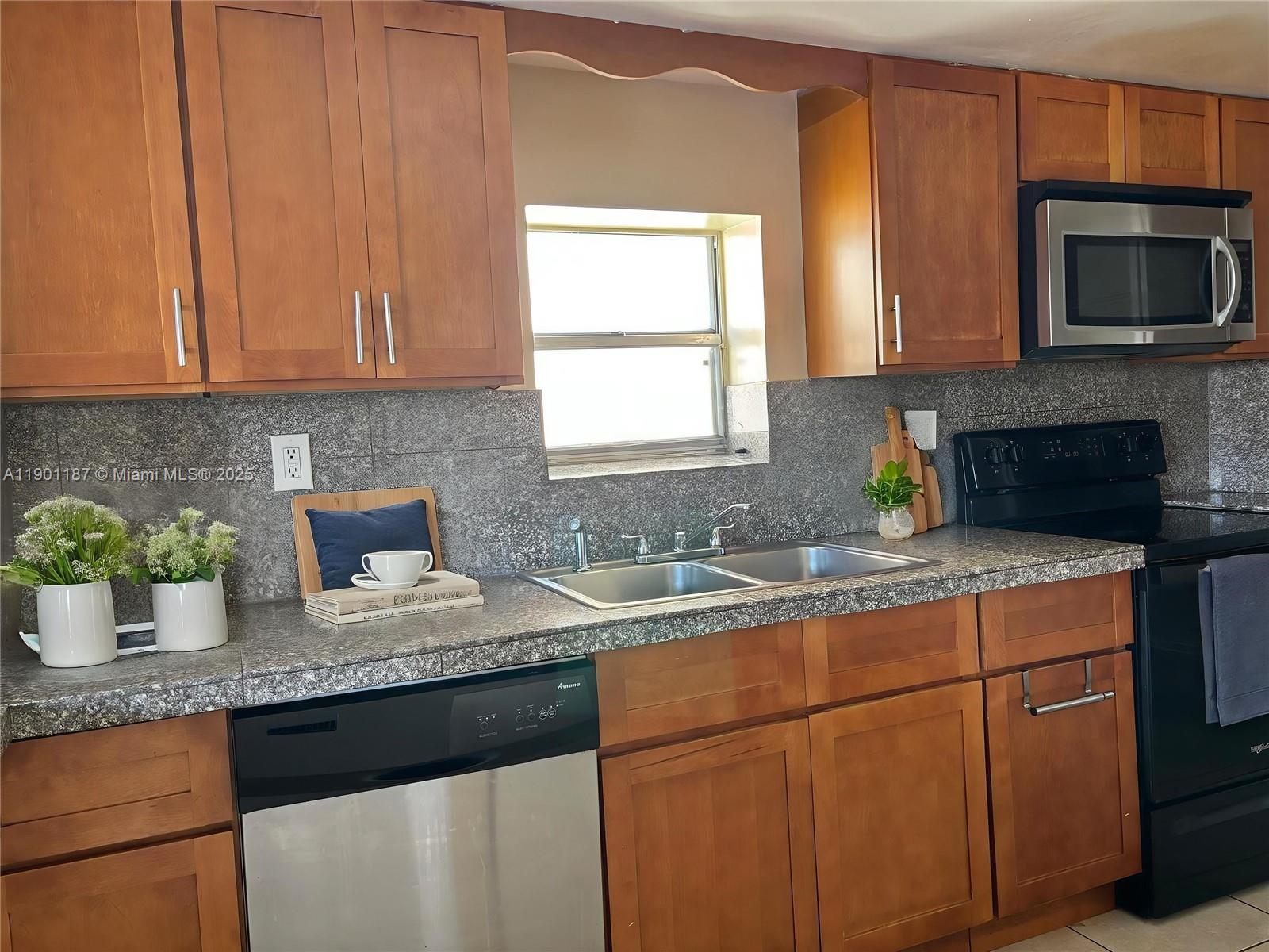 6541 Southwest 41st Court, Unit 173 Davie, FL 33314 - Photo 5 of 24 a kitchen with granite countertop a sink stainless steel appliances a window and a counter space