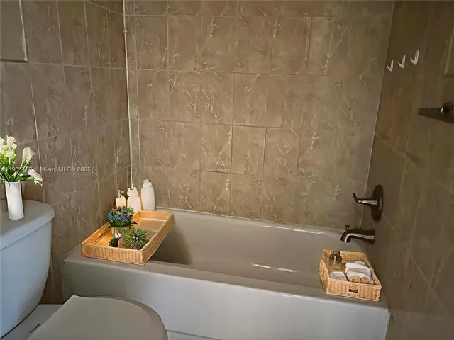 a bathroom with a tub a sink and toilet