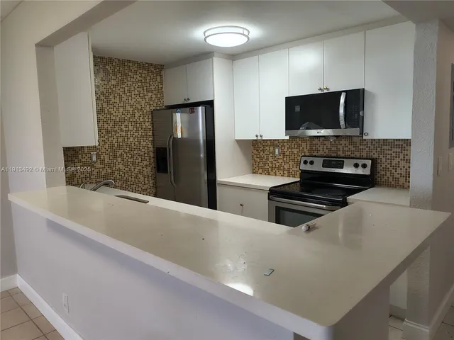 a kitchen with stainless steel appliances a stove microwave and refrigerator