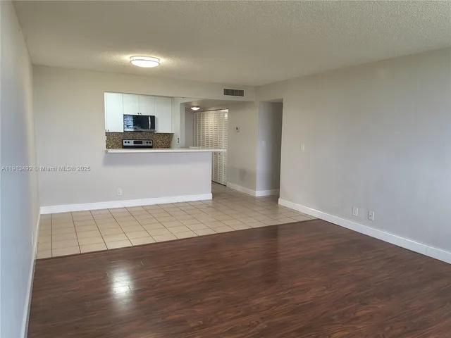 a view of a kitchen with wooden floor and a sink
