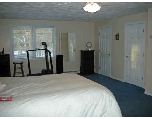 63 Long Pond Road Tyngsborough, MA 01879 - Photo 8 of 16 a bedroom with a bed and wooden floor