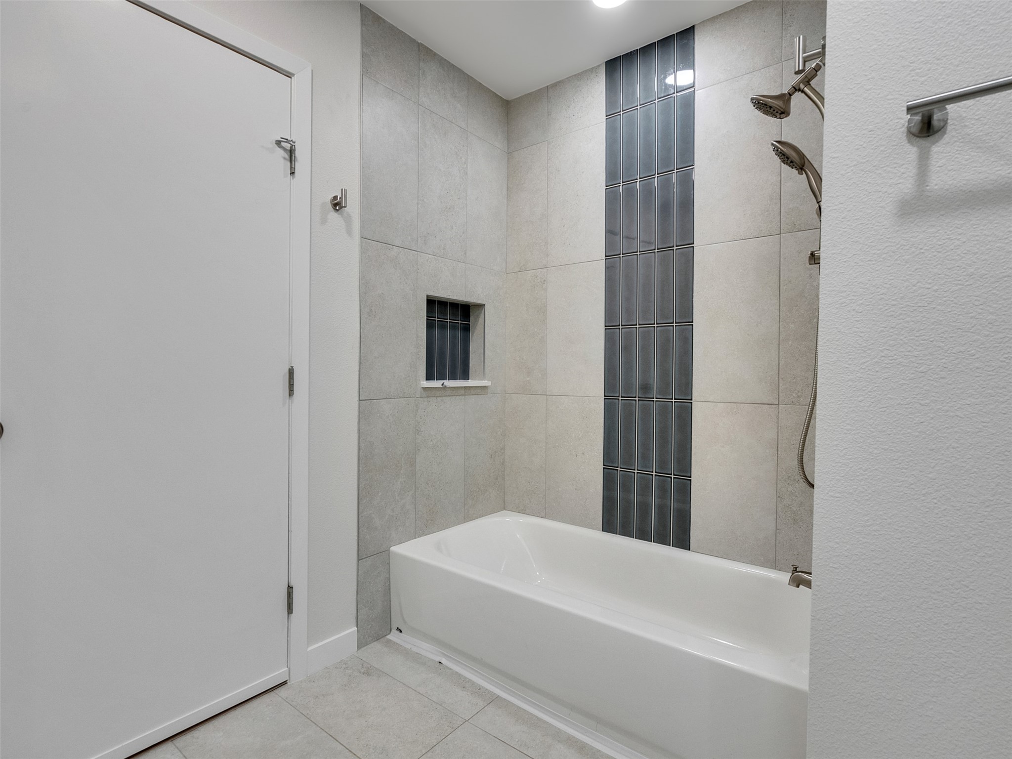 10315 Winding Trail Road La Porte, TX 77571 - Photo 13 of 24 This sleek bathroom features a modern shower and tub combo with elegant tile accents, offering both style and functionality for your daily retreat.