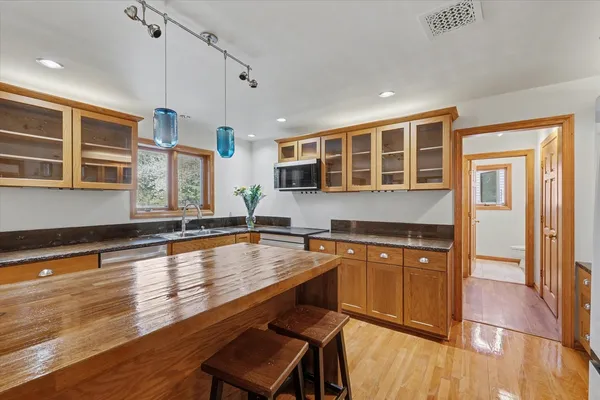a kitchen with stainless steel appliances granite countertop a refrigerator a stove top oven and a sink