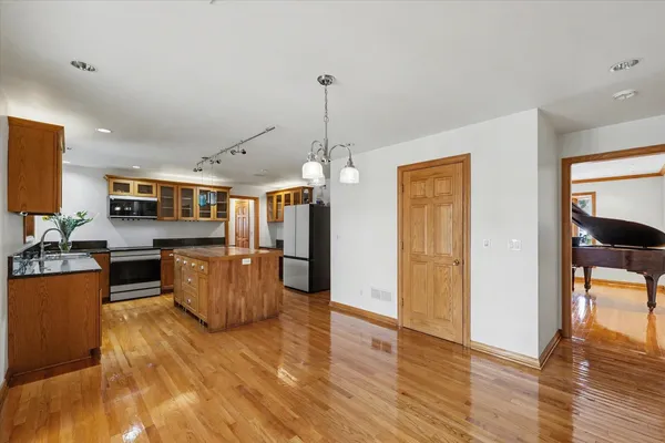 a view of an empty room with wooden floor fireplace and a window
