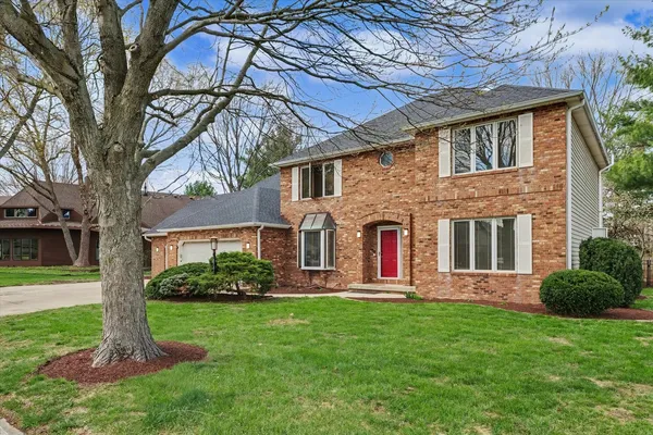 a front view of a house with a yard and an trees