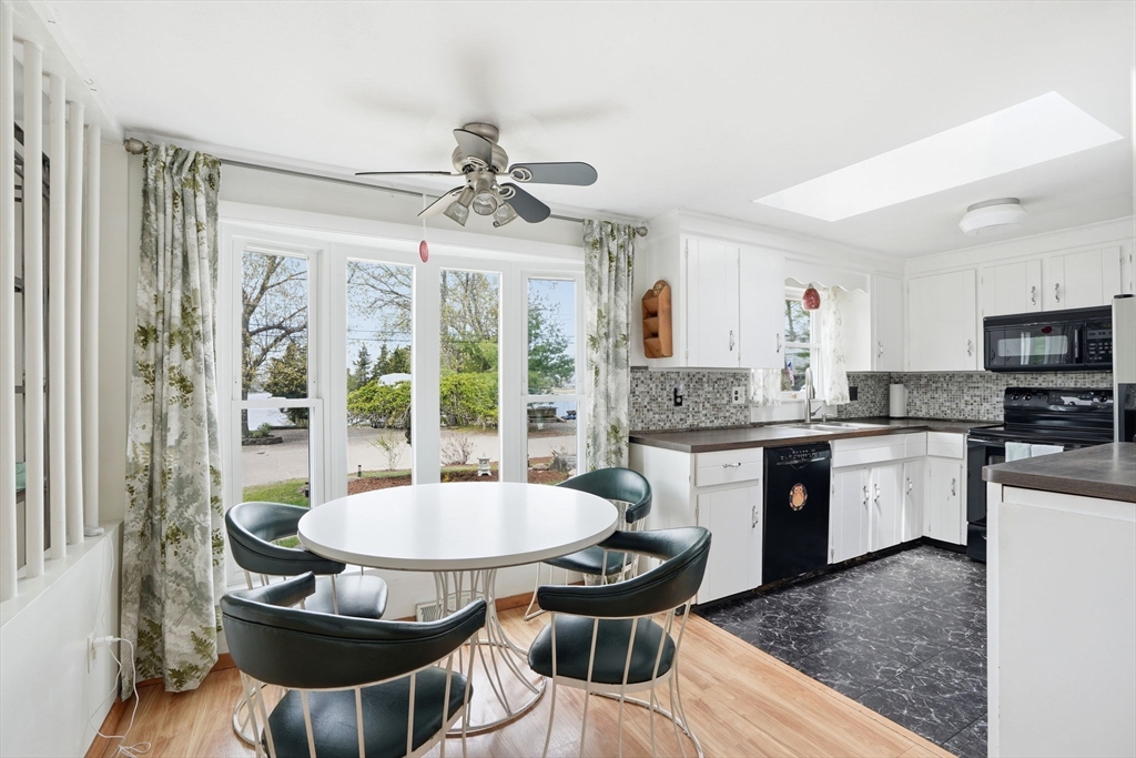 94 Edgewater Drive Wareham, MA 02571 - Photo 20 of 37 a kitchen with a dining table chairs and white cabinets