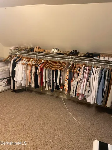 a view of walk in closet with clothes and shoes
