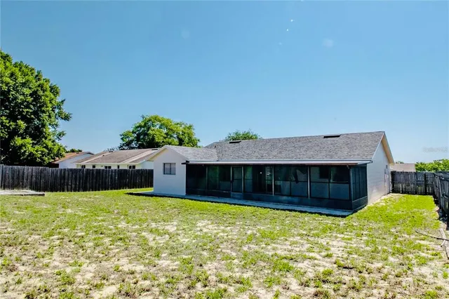 a view of a house with a backyard and a large tree
