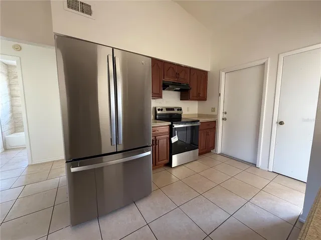 a kitchen with stainless steel appliances granite countertop a refrigerator and a sink