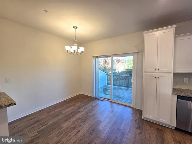 a view of a room with wooden floor and chandelier