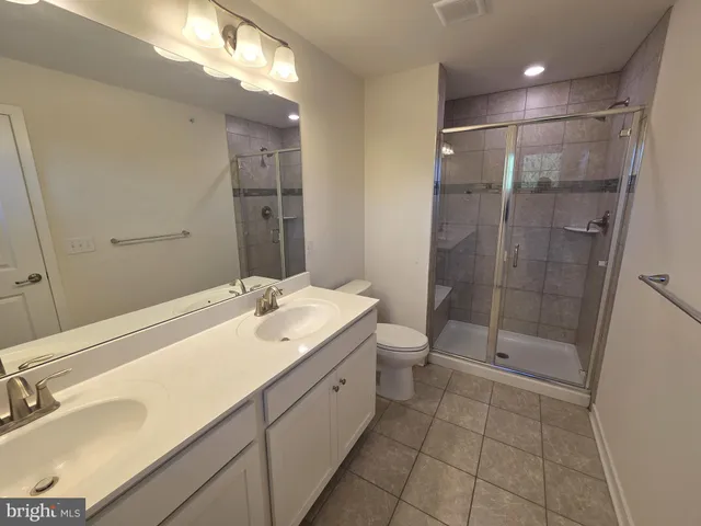 a bathroom with a double vanity sink toilet and shower
