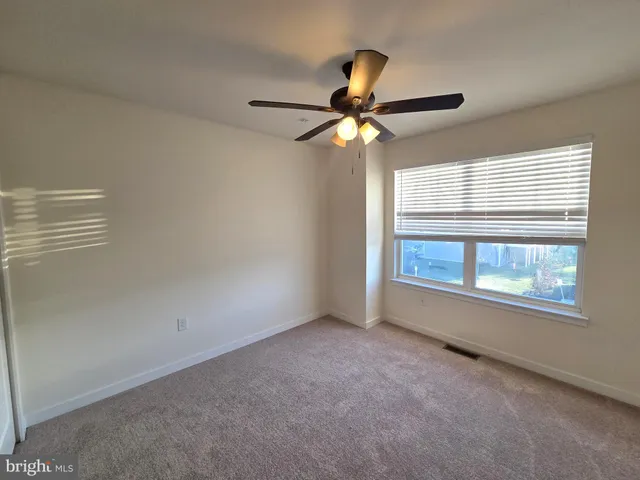 en empty room with windows and fan